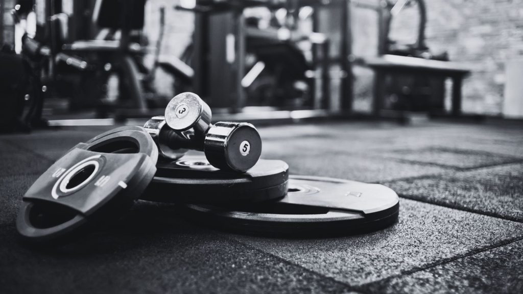 Why what's working often gets abandoned in business - Black and white photo of weights stacked on a gym floor